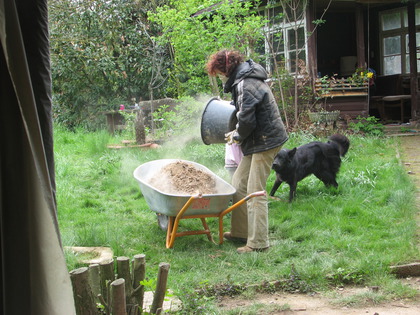 Teile des Lehmschutts wird mit der Schubkarre im Garten verteilt