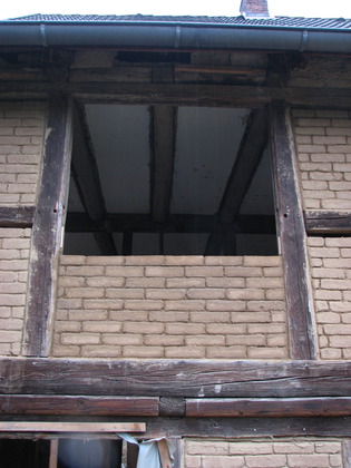 Ein Fach mit Lehmsteinen in Erwartung eines Fensters