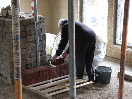 Gerd stapelt Klinker auf eine Palette im Haus um