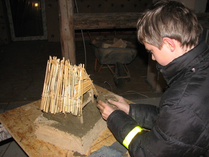 Morien arbeitet am Lehmhausmodell