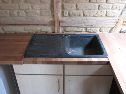 Die Küchenspüle in der Arbeitsplatte aus Mahagoni