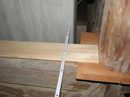 Ein Holzbrett dient als physikalische Längenreferenz zwischen den Fachwerkbalken