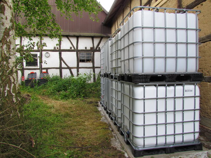 Die Regenwassercontainer IBC Tanks auf dem Betonsockel