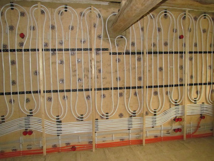 Viele Wandheizungsrohre und Elektroinstallation