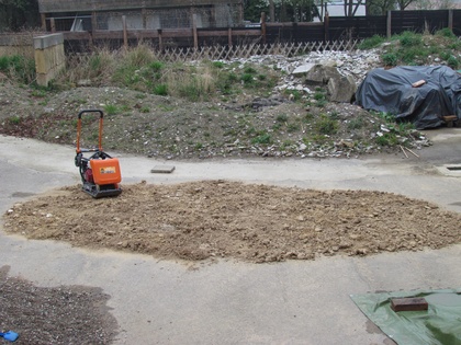 Rüttelplatte vor dem verteilten Recycling Lehm aus dem Abriß