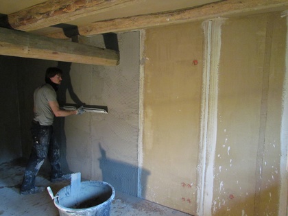 Der Kalkputz wird mit der kurzen Kartätsche entlang der Putzprofile abgezogen