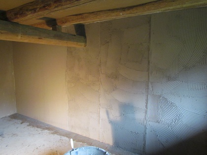 Von hinten wird die zweite Lage Kalkputz aufgetragen und abgezogen