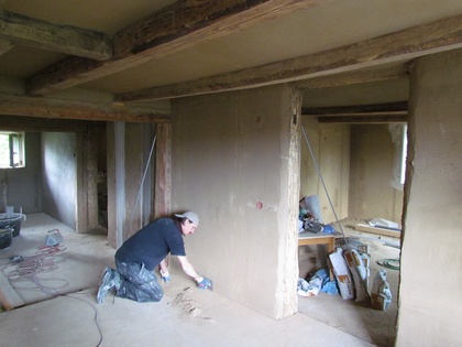 Der Boden wird saubergekratzt bevor die Arbeiten mit dem Kalkputz beginnen