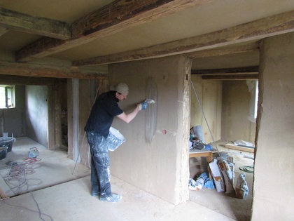 Es werden Kalk Kaseinstreifen an die Wand gepinselt um dem Kalkputz halt zu geben