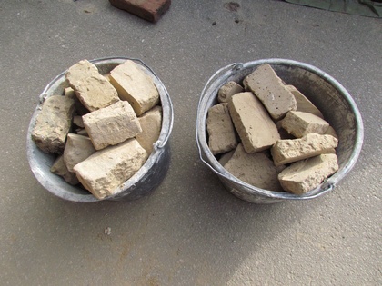 Zwei Eimer mit Lehmsteinscheiben Zwei Eimer mit Lehmsteinscheiben